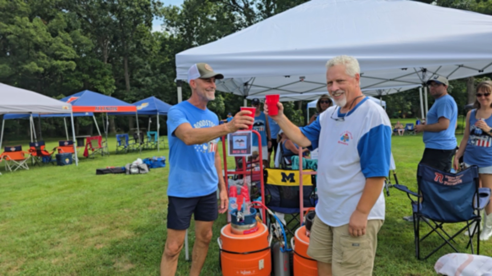 Friends toasting next to the beer kegs at Roodstock