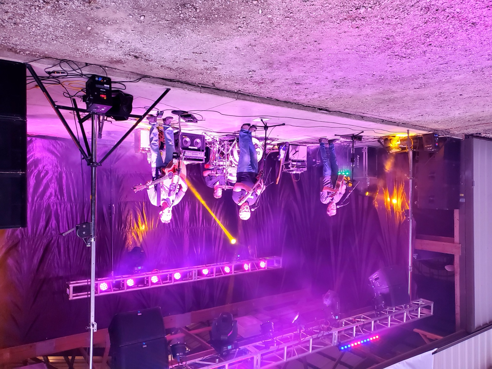 Live band performing on stage under purple lights